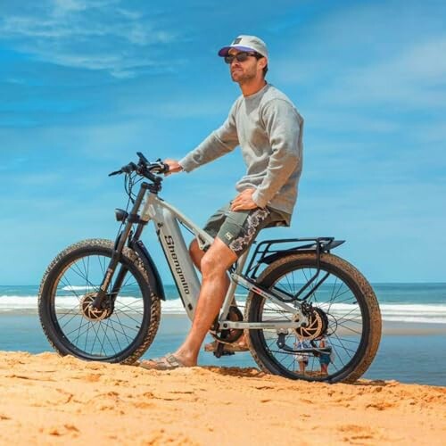 Man met elektrische fiets op het strand