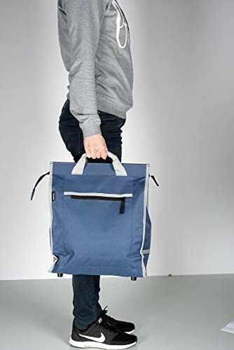 Persoon met blauwe tas in hand